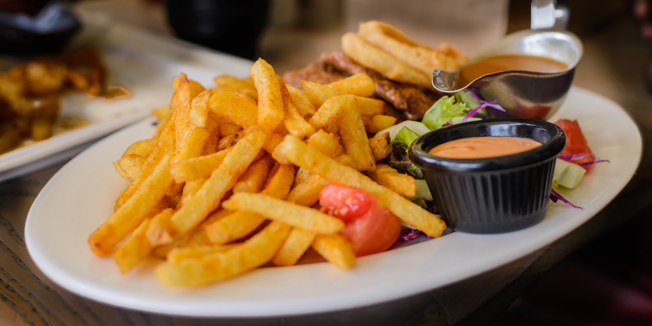 an image of middle east Harissa fries served on a plate with sauce