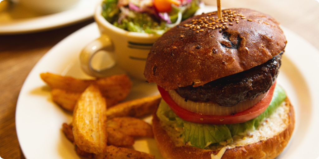 A plate featuring a juicy burger with lettuce and tomato, accompanied by a side of golden, crispy fries