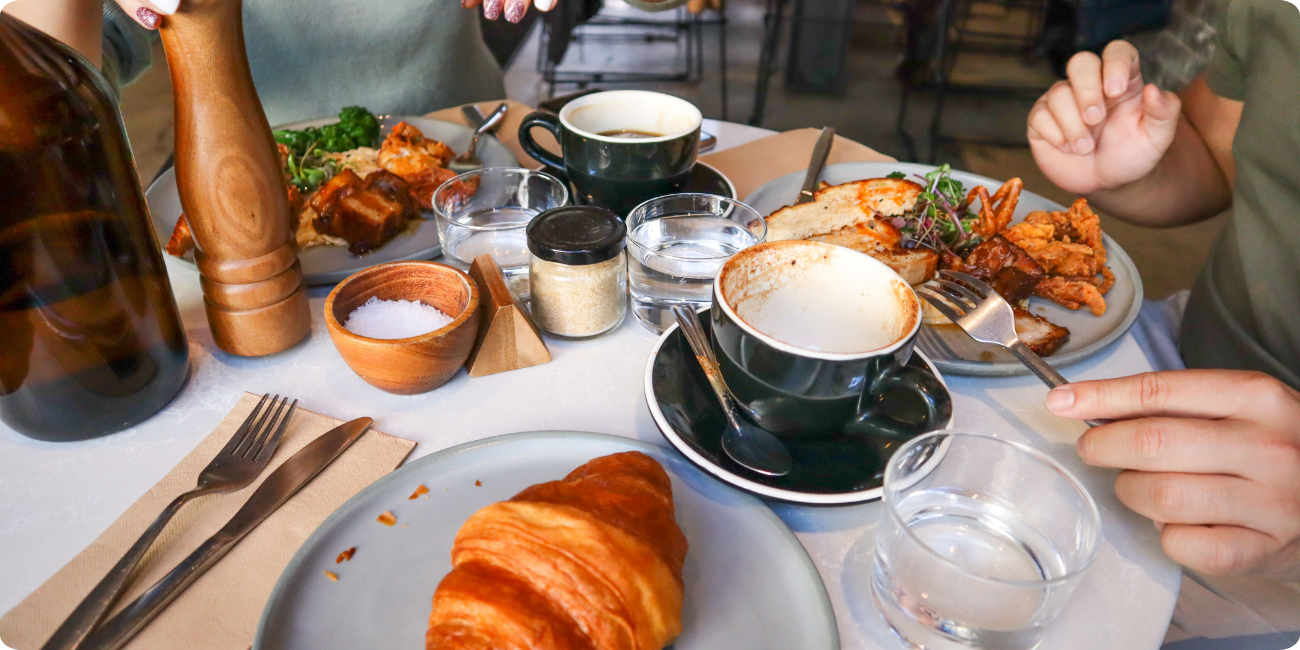 A table set with various multi-cuisine dishes and drinks, positioned behind vibrant yellow doors