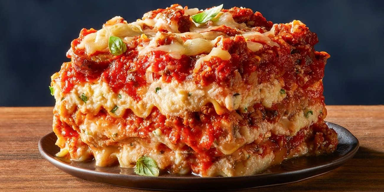 A close-up of a plate with a stacked lasagna, highlighting its cheesy layers and savory sauce