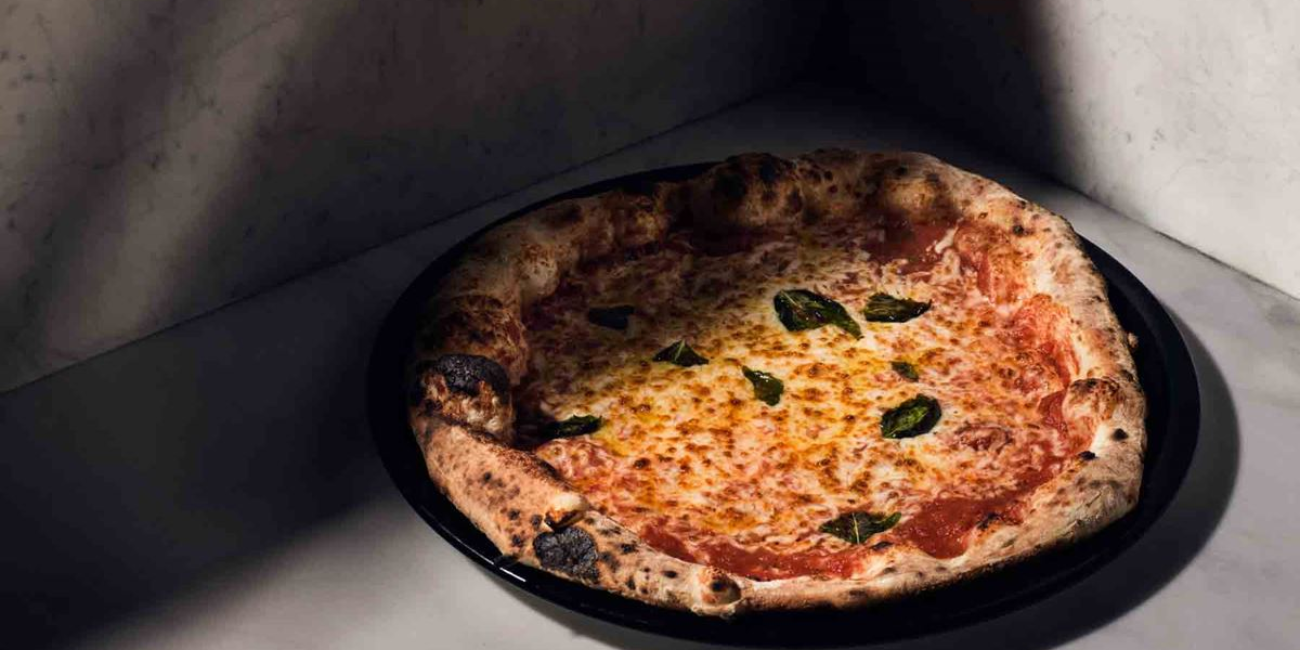 A delicious pizza resting on a sleek marble surface, highlighting its appetizing toppings and crispy edges.