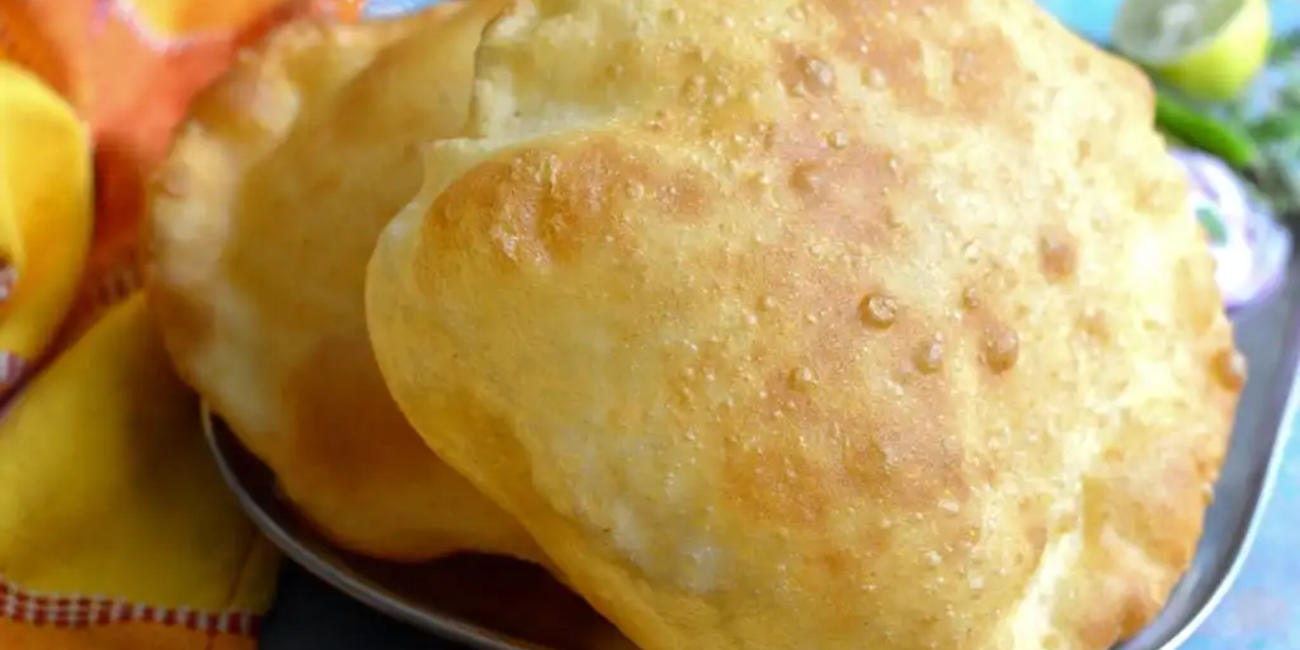 Two freshly baked flatbreads arranged on a white plate, highlighting their soft texture and warm appearance.